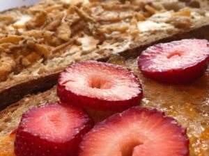 Onions on cream cheese; fresh strawberries on apricot preserves both served on a Peasant boule slice from Grand Central Baking Company. 