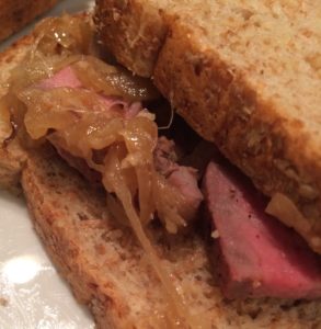 Caramelized onions and steak sandwich on whole wheat bread.