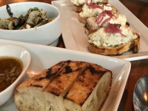 Grilled sun choke salad with Aioli, scallion and mint (top left), smoked fish crostini with pickled onion (top right), and grilled macrina foccacia with bang caudal (bottom): my meal at Anchovies & Olives.